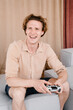 © Alina Hvostikova/Stocksy - Cheerful young man playing video game at home
