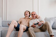 © Alina Hvostikova/Stocksy - Cheerful senior father and son playing video game