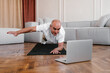 © Alina Hvostikova/Stocksy - Senior man with laptop having online training at home