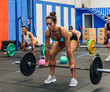 © David Prado/Stocksy - Muscular woman during weightlifting workout with group