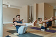 © Javier Pardina/Stocksy - Yoga teacher in class with her students