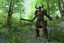 Fantasy Warrior With Horned Helmet And Sword Drawn In Forest