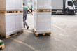 © Jelena Jojic Tomic/Stocksy - One man operates the pallet jack in a warehouse full of shipping goods