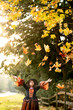 © Jennifer Bogle/Stocksy - Girl in witch costume under falling leaves