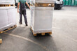 © Jelena Jojic Tomic/Stocksy - One man operates the pallet jack in a warehouse full of shipping goods