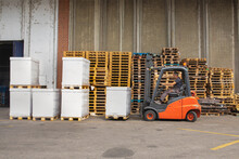 The Worker Transports Freight Using A Forklift