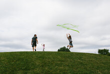 Kids Flying Kite On A Hill