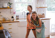 © Rob and Julia Campbell/Stocksy - Two sisters having fun baking cookies together in a modern kitch