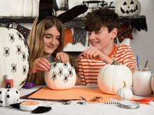 Family Decorating Pumpkins With Spiders