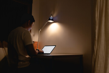 Asian man is working at night with warm light lamp. Concept of work late.