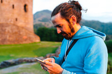 Adult Tourist Using Smartphone Close To Castle