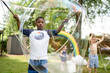 © Jennifer Bogle/Stocksy - Black boy making huge bubbles