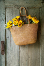Straw Purse With Sunflowers On Old Green Door