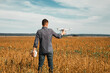 © Ruslan Ivantsov - A man standing near the car launches a drone. drone flight in yellow field..