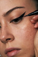 Woman With Freckles Applying Eyeliner