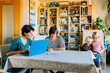 © MyMicrostock/Stocksy - Lesbian mothers with kids working with laptop at home