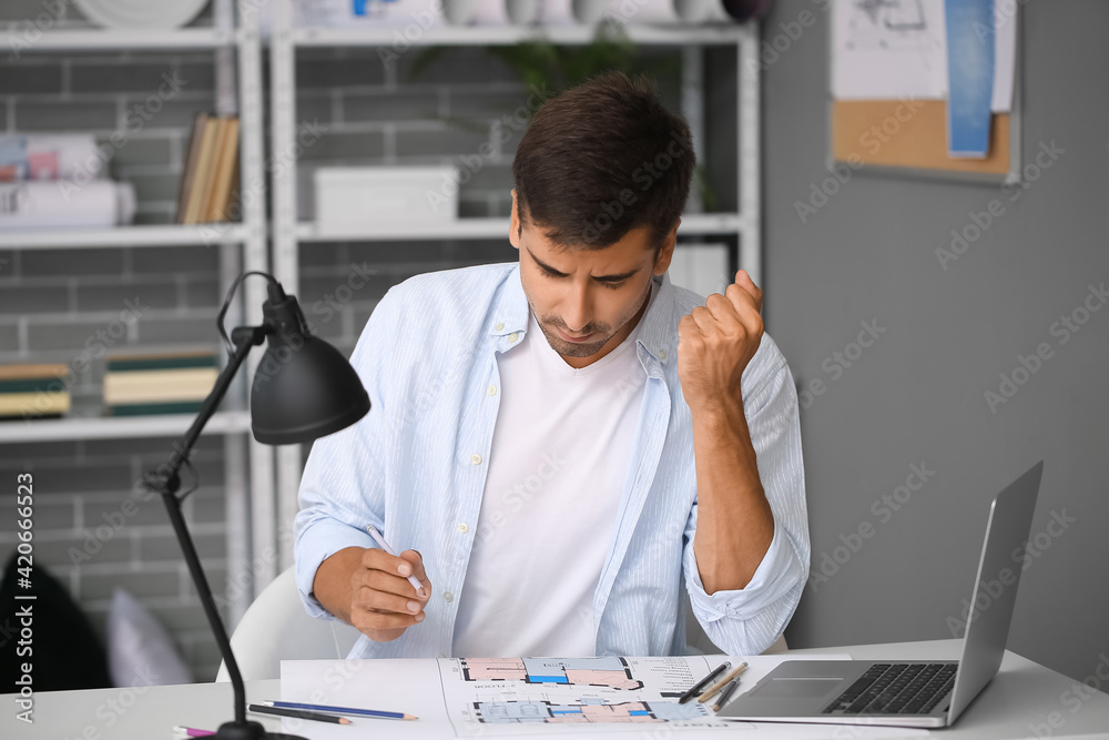 Portrait of stressed young man in office