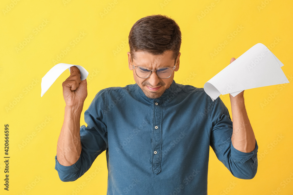 Portrait of stressed young man on color background