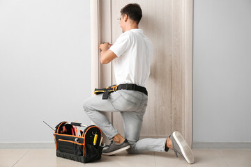 Construction worker repairing door indoors