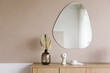 © Dreamwood Photography/Stocksy - Mirror and wooden cabinet with decorative elements in room