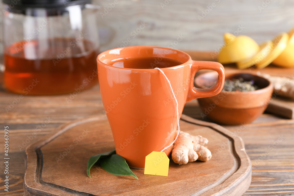 Cup of aromatic black tea on wooden background