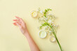 © Pixel-Shot - Female hand with jars of cream and beautiful flowers on color background