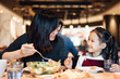© MaaHoo Studio/Stocksy - Mom and kid eating in the restaurant