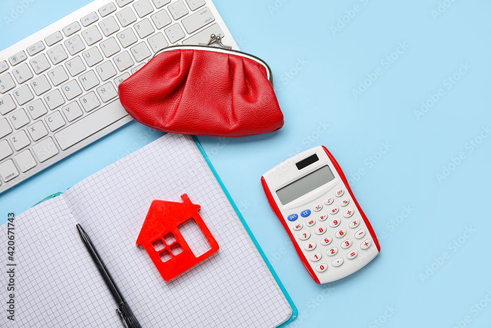 Calculator with model of house, notebook, wallet and computer keyboard on color background