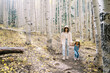 © Daniel Kim Photography/Stocksy - Mother and child walking on forest trail