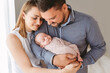 © Lea Csontos/Stocksy - Proud and happy parents with their newborn baby