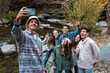 © Bisual Studio/Stocksy - Group of friends taking a selfie photo in autumnal day