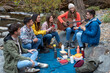 © Bisual Studio/Stocksy - Friends doing picnic and playing guitar outdoors