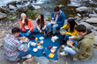 © Bisual Studio/Stocksy - Friends having lunch at nature on autumn day