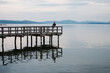 © Jarusha Brown Photography/Stocksy - Man relaxing on a pier looking out at a calm lake.