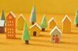 © Maki Company Limited/Stocksy - Miniature houses village over yellow background,