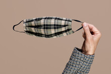 Man Holding A Plaid Face Mask