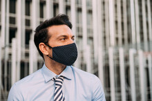 Businessman In Protective Mask Looking Away In City