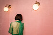 © ulas & merve/Stocksy - woman with green outfit in a pink room