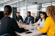 © Sergio Marcos/Stocksy - Crop diverse attentive businesspeople during a meeting in a modern work space