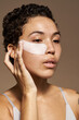 © Javier Díez/Stocksy - African American woman with cosmetic patches on face