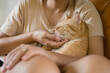 © Chalit Saphaphak/Stocksy - Asian woman hugging orange cat