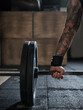 © Miquel Llonch/Stocksy - Male tattoo arm and weightlifting