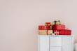 © Alina Hvostikova/Stocksy - Stack of Christmas gifts on cupboard