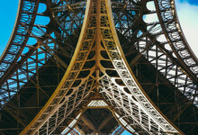 Inside The Eiffel Tower In Paris, France. View To The Inside Of Eiffel Tower. Big Symetrical Building. Close Up Shot In The Morning. Blue Sky With A Sunny Weather