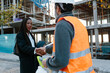 © Jimena Roquero/Stocksy - Woman engineer shaking hand with construction foreman in front of construction.