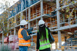 © Jimena Roquero/Stocksy - Back of Woman engineer and construction worker checking the development of a building in construcion.