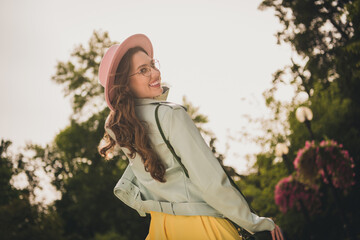 Wall Mural - Rear photo of charming cheerful young lady toothy smile look camera have good mood free time outdoors