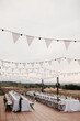 © Melissa Milis Photography/Stocksy - Outdoor wedding reception with white bunting flags and string lights