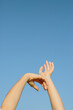 © Tanya Yatsenko/Stocksy - Woman's hands over blue sky