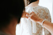 © Melissa Milis Photography/Stocksy - mother buttoning up Bride's wedding dress